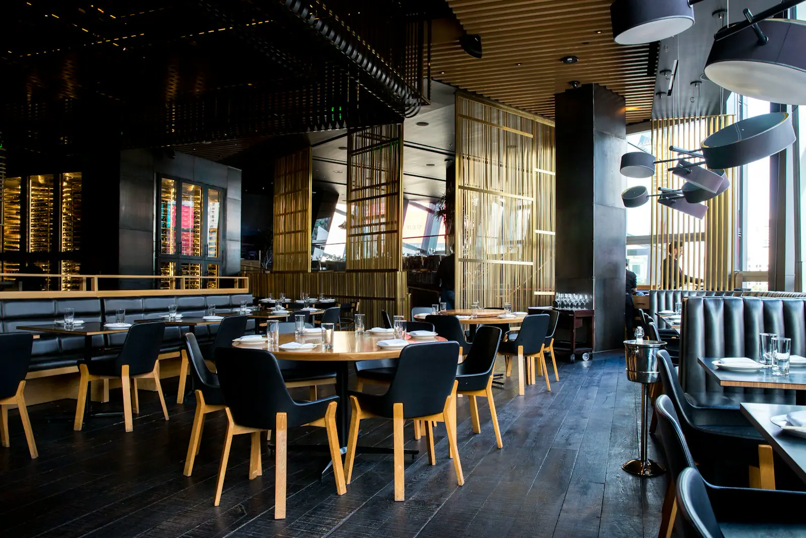 A busy full-service dining room with many occupied tables and servers carrying plates
